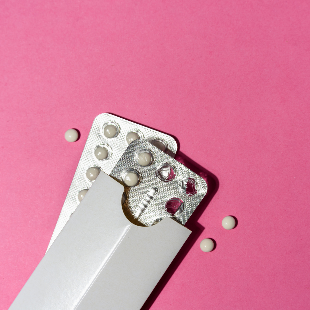 Birth control pills on a pink background